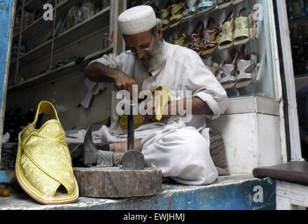 Peshawar. 27. Juni 2015. Ein pakistanischer Mann bereitet traditionelle Peshawari Chappal bei einem Workshop in Nordwest-Pakistan Peshawar, 27. Juni 2015. Peshawari Chappal ist ein traditionelles Schuhwerk von Pakistan, getragen vor allem von Paschtunen Khyber Pakhtunkhwa Region von Pakistan. © Ahmad Sidique/Xinhua/Alamy Live-Nachrichten Stockfoto