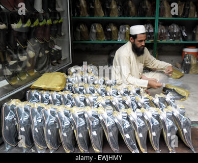 Peshawar. 27. Juni 2015. Ein pakistanischer Mann packt traditionelle Peshawari Chappal beim Workshop in Nordwest-Pakistan Peshawar, 27. Juni 2015. Peshawari Chappal ist ein traditionelles Schuhwerk von Pakistan, getragen vor allem von Paschtunen Khyber Pakhtunkhwa Region von Pakistan. © Ahmad Sidique/Xinhua/Alamy Live-Nachrichten Stockfoto