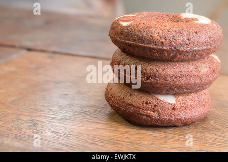 Drei Brownie Donuts Top mit Mandeln ordnen, um auf den Holztisch Turm Stockfoto