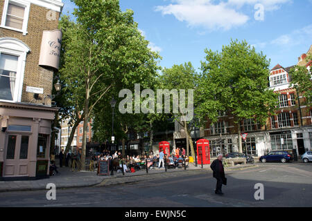 Massen zum Entspannen in der Sonne auf Clerkenwell Green, London Stockfoto