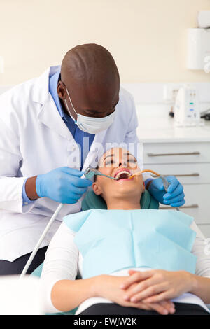 Afrikanische amerikanische Zahnarzt reinigen und Polieren der Zähne eines Patienten Stockfoto