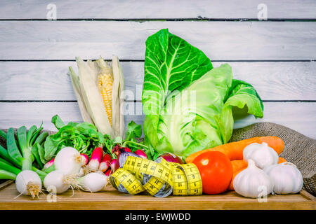 Gemischtes Gemüse auf einem Holztisch mit Maßband Stockfoto