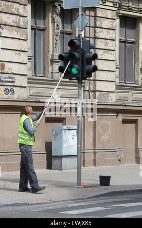 Mann Reinigung Ampel in Riga Stockfoto