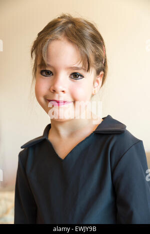 Kleine Mädchen Porträt Make-up trennten sich in die Augen und Lippen gemalt und in schwarz gekleidet und isoliert auf weißem Hintergrund Stockfoto