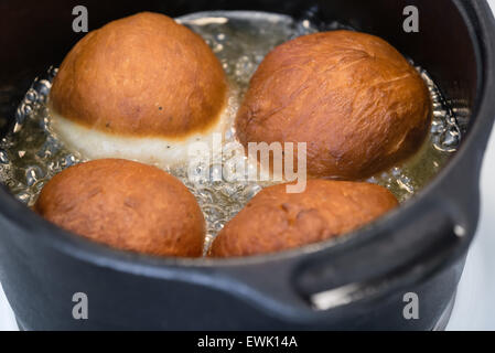 Hausgemachte Krapfen Frittieren in Öl Stockfoto