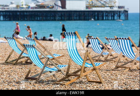 Traditionelle Old-fashioned blau-weiß gestreiften Liegestühlen am Strand vor dem Palace Pier, Brighton, East Sussex, UK Stockfoto