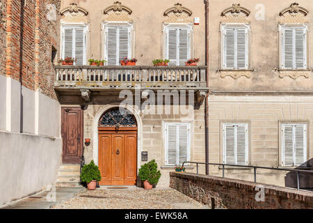 Fassade des typisch italienischen Haus mit Balkon und Holztür in Stadt von La Morra im Piemont, Norditalien. Stockfoto