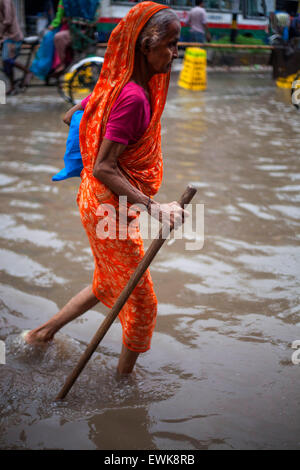 Dhaka, Bangladesch. 27. Juni 2015. Eine alte Frauen gehen auf aufgeweichten Straßen bei Regen in Dhaka am 27. Juni 2015.Heavy Regen in der Stadt weiter für eine vier aufeinander folgende Tage zuzufügen, endlosen leiden die Menschen wie Staunässe Bildungs- und geschäftliche Aktivitäten behindert. Bildnachweis: Zakir Hossain Chowdhury Zakir/Alamy Live-Nachrichten Stockfoto