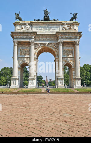Einige Touristen an den Parco Sempione, Arch of Peace (Porta Sempione) und den Scorfesco Palast im Hintergrund, Mailand, Italien. Stockfoto
