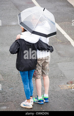 Poole, Dorset, UK. 28. Juni 2015. UK-Wetter: nass feucht Start in den Tag bei Poole - paar Schutz unter Regenschirm Arm in Arm Credit: Carolyn Jenkins/Alamy Live News Stockfoto