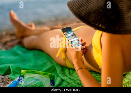 Frau mit Handy am Strand Stockfoto
