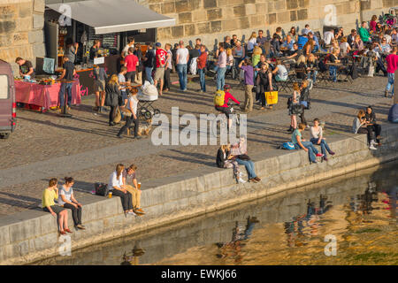 Prag, Blick auf junge Menschen entlang der Ufer der Moldau in Prag gesammelt an einem Sommernachmittag, Tschechische Republik. Stockfoto