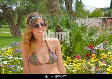 Junges Mädchen posiert in bunten Garten in bikini Stockfoto
