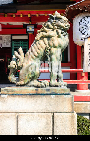 Seitliche Sicht auf eine der beiden, Komainu, eine steinerne Statue Wächter Hund am Eingang zu den wichtigsten Gottesdienst Halle des Ikuta Heiligtum in Kobe, Japan. Stockfoto