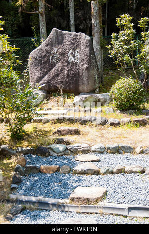 Japan, Kyoto, Arashiyama, Danrinji Tempel. Weg mit Sprungbrett, Tobi-ishi und die Heilige Rock im Garten mit japanischen Kanji Inschrift. Stockfoto