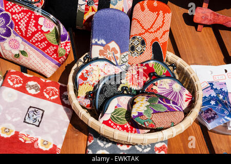 Japan, Kyoto. Strohkorb auf Tisch im Freien, mit bunten gewebt Damen Geldbörsen mit traditionellen Japanischen Muster als Souvenirs verkauft werden. Stockfoto