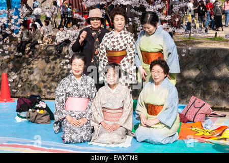 Sechs älteren japanischen Frauen posieren für ein Foto mit einem Cherry Blossom Partei durch die Shukugawa River. Fünf der Frauen Kimonos tragen. Stockfoto