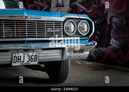 Eine blaue American Vintage Chevrolet vor dem Hintergrund der Straßenkunst. Stockfoto