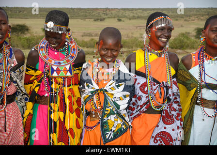 Masai Frauen tragen bunten Tracht, singen, lachen und Lächeln in einem Dorf in der Nähe der Masai Mara, Kenia, Afrika Stockfoto