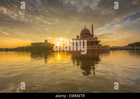 Einen schönen Sonnenaufgang am Putra Moschee, Putrajaya, Malaysia zeigt bunte Wolken, Sunburst und Reflexion an der Seeoberfläche Stockfoto