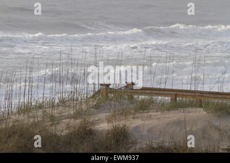 Malerische Holztreppe nach unten auf einen Strand durch eine stürmische See bedeckt führenden Stockfoto