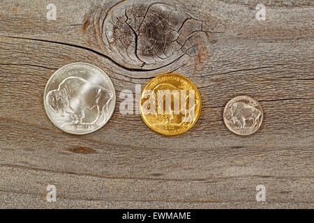 United States Mint herausgegeben Rückseite American Buffalo Münzen, bestehend aus Silber, Gold und Nickel Metalle auf rustikalen Holz. Stockfoto