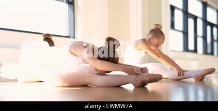 Kleines Ballett Mädchen machen ein Stretching Warm Up Übung in the Studio bevor ihre Tanz-Praxis. Stockfoto