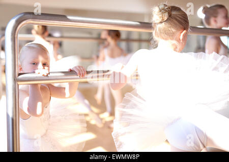 Kleine weiße Ballerinas machen eine Streckung üben mit einer Ballett-Reck am Tanzstudio. Stockfoto
