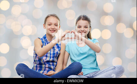 glückliche kleine Mädchen zeigen Herzform hand Zeichen Stockfoto