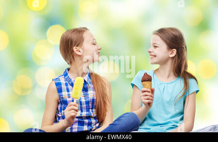 glückliche kleine Mädchen essen Eis über grün Stockfoto