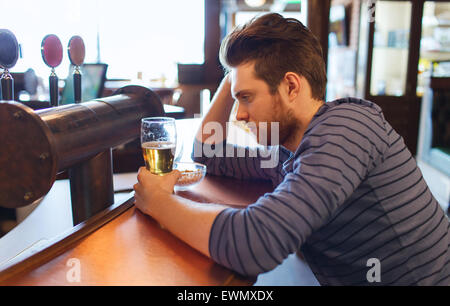 unglücklich einsamer Mann trinken Bier in Bar oder Kneipe Stockfoto