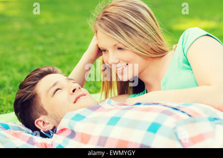 lächelnde paar liegend auf einer Decke im park Stockfoto