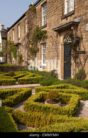 Großbritannien, England, Derbyshire, Ashford im Wasser, Church Street, ordentlich abgeschnitten formale Box Taxushecke vor Garten Stockfoto