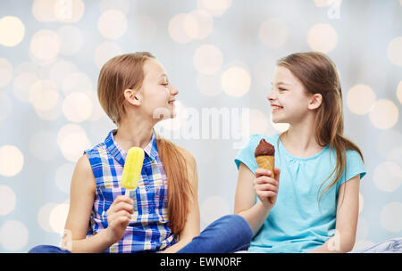 glückliche kleine Mädchen essen Eis über Lichter Stockfoto