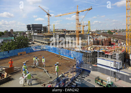 Arbeiter Gießen auf einer neuen Wohnanlage bei Vauxhall, London, während ein weiteres Großprojekt im Hintergrund verarbeitet wird Beton Stockfoto