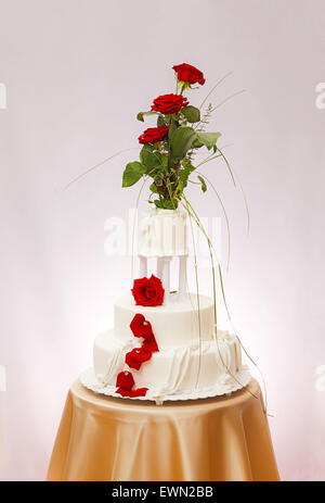 Dreistöckige weisse Hochzeitstorte mit echten Rosen Dekoration Stockfoto