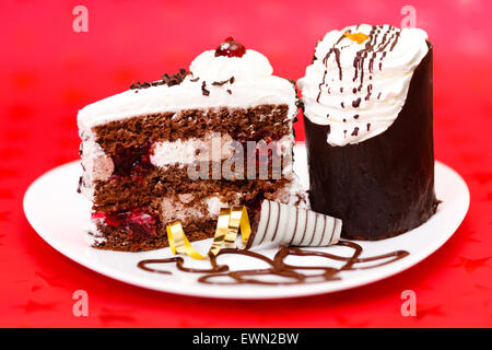 Zwei Scheiben Schokolade Torte auf rotem Grund Stockfoto