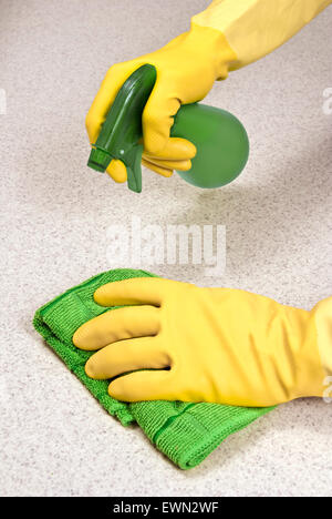 Hände mit Gummihandschuhen Zähler mit Lappen und Spray Reiniger reinigen. Stockfoto