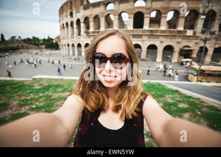 Hübsche junge weibliche Touristen nimmt Selfie Foto nahe Kolosseum in Rom, Italien Stockfoto