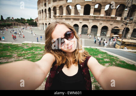 Hübsche junge weibliche Touristen nimmt Selfie Foto nahe Kolosseum in Rom, Italien Stockfoto