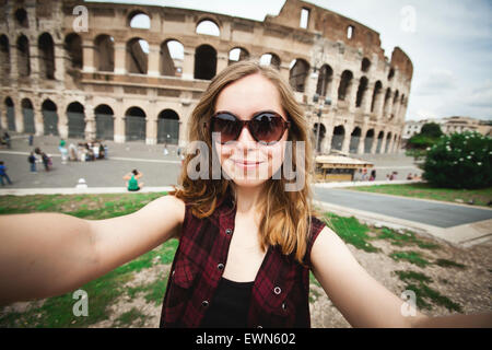 Hübsche junge weibliche Touristen nimmt Selfie Foto nahe Kolosseum in Rom, Italien Stockfoto