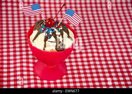 Amerikanische Flaggen auf ein hot Fudge Eisbecher mit roten, weißen und blauen Streuseln. Stockfoto