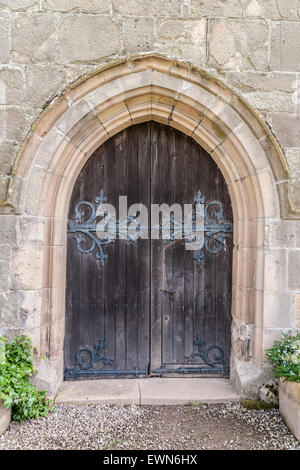 Alte Holzkirche Tür mit wrough Bügeleisen blättern und Sandstein gewölbten Vorhalle Stockfoto