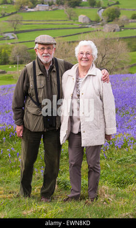 Ein altes Ehepaar, ein Spaziergang durch Glockenblumen über Austwick in den Yorkshire Dales, UK. Stockfoto