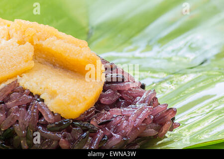 Schwarzer Klebreis mit Vanillesauce, eingehüllt in Banane Blätter Stockfoto