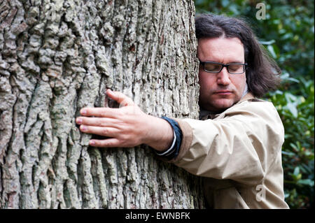 Man gibt einem riesigen Baum eine Umarmung Stockfoto