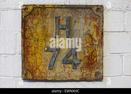 Ein wirklich Alter aussehende Hydranten Schild aus Gusseisen und mit einem gelben Hintergrund und fetten schwarzen Buchstaben gemalt. Stockfoto