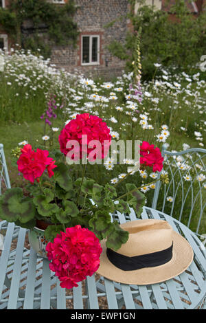 Garten-Stillleben mit Geranien Daises und Gartentisch Stockfoto