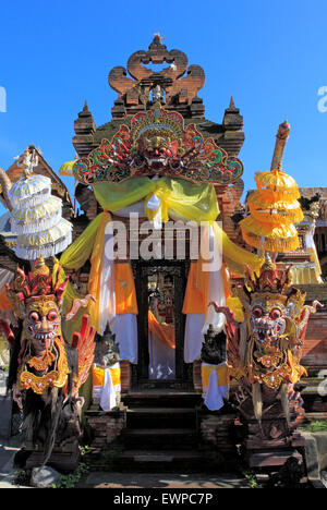 Eingang eines Hauses, mit bunt bemalten Drachen Statuen geschmückt, mit Sonnenschirmen und einen Barong Maske. in der Nähe von Ubud, Bali. Stockfoto