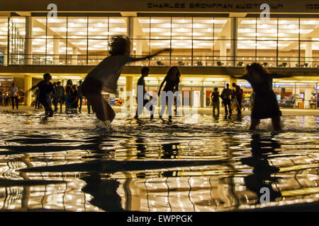 Silhouette Kinder spielen im Wasser-Brunnen in der Nacht. Stockfoto